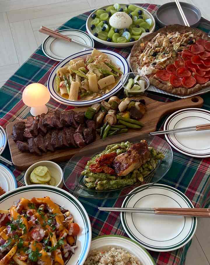 Cozy home party dining table with plaid tablecloth and assorted foods arranged elegantly