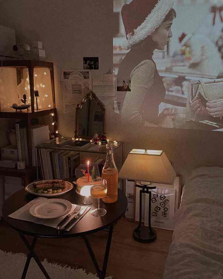Warm beige and brown tone studio apartment featuring a folding table, vintage decor, and a mini projector in a cozy bedroom setting