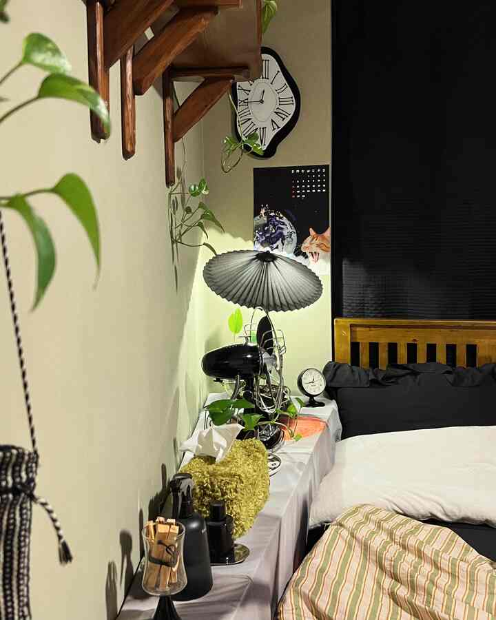 A white and black toned bedroom featuring a bed with side table and a poster, creating a cozy atmosphere
