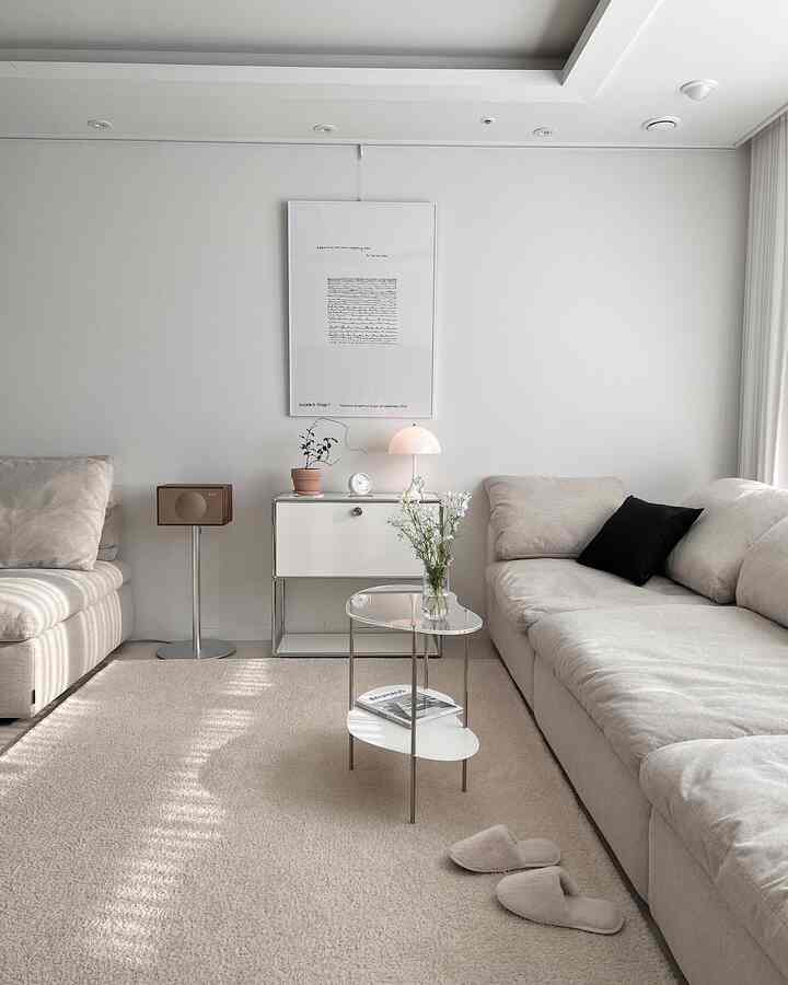 Beige-toned living room featuring two sofas and a small glass coffee table with a warm, clean interior ambiance