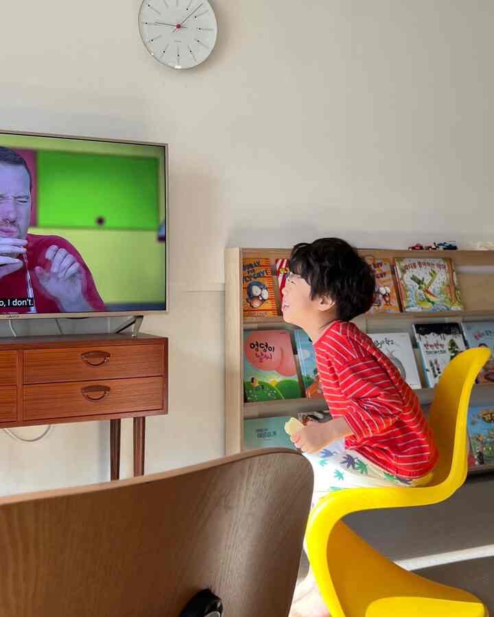 暖かいナチュラル調の子供部屋、黄色い椅子と本棚が配置され、子供に優しい雰囲気のある空間