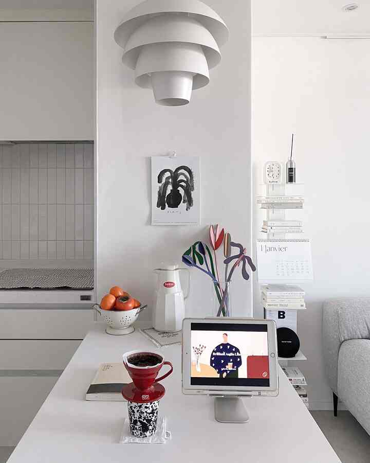 白を基調とした小さなキッチンとおうちカフェ空間、シンプルで洗練されたインテリアで読書とコーヒーを楽しむ室内