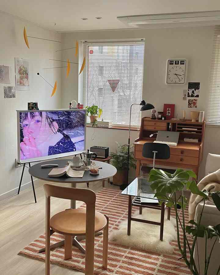 A natural modern compact living room featuring wood tone furniture and white blinds creating a cozy atmosphere