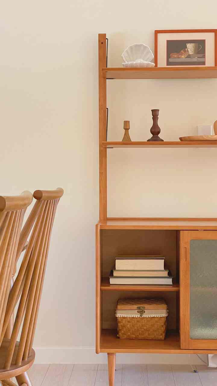 Warm and simple dining space featuring natural wood tone shelves and chairs