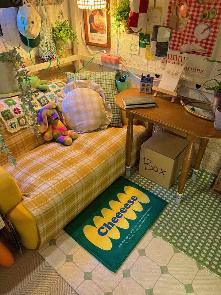 ベージュとグリーンの色調の小さな部屋、チェック柄のソファと木製のサイドテーブルが配置された居心地の良いヴィンテージ感のあるインテリア