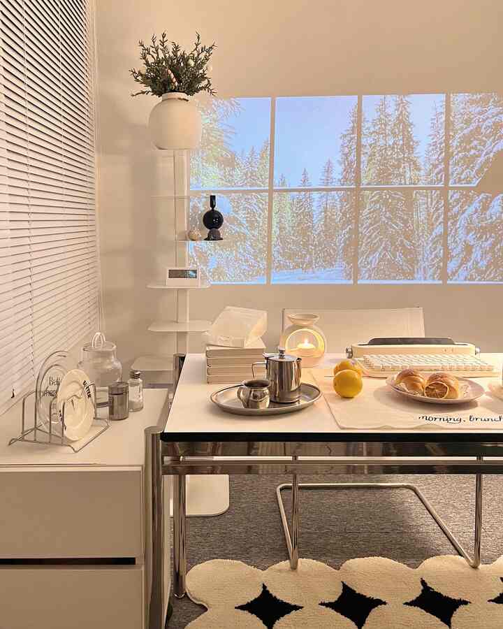 White and metal toned dining room featuring a simple modern table set with tea accessories and lemons, creating a cozy atmosphere