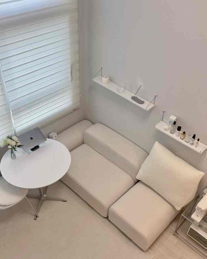 白を基調とした清潔感あるリビング、丸テーブルとモジュラーソファが配置されたシンプルで居心地の良い空間