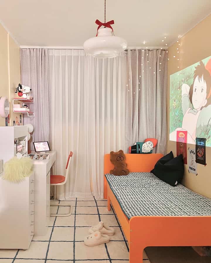 オレンジのベッドとベージュの壁がある小さな寝室、プロジェクターで映像を投影した雰囲気のある空間