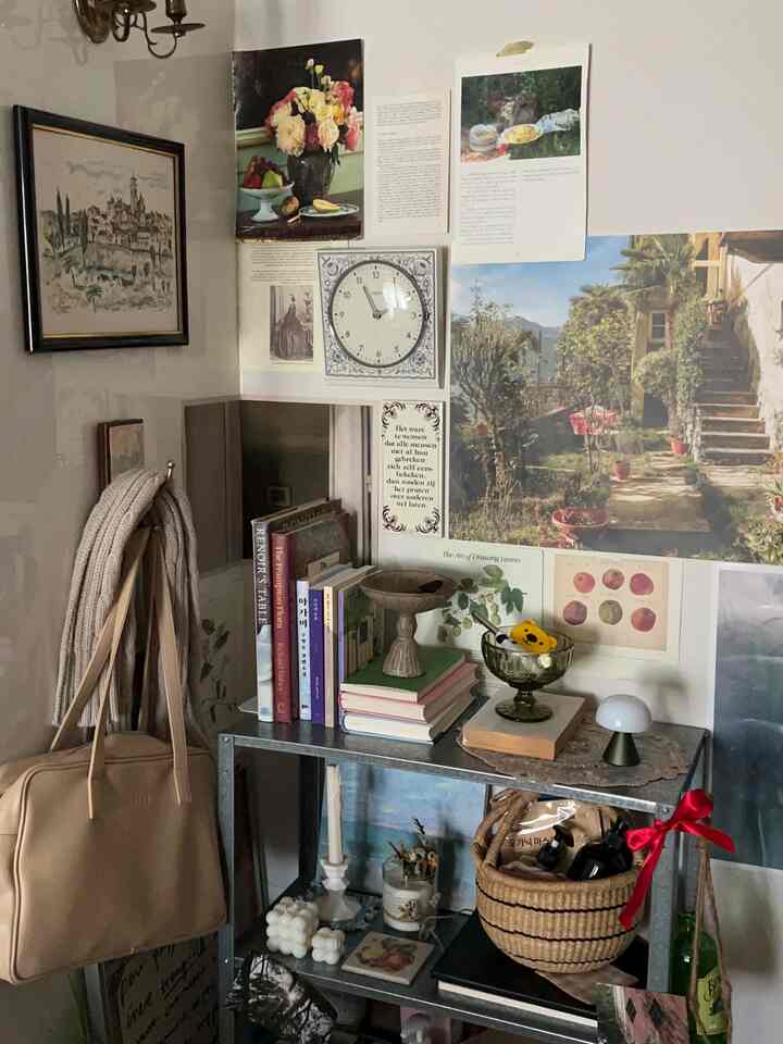 Cozy wall space featuring vintage decor, picture frames, and a wall clock, with metal shelving and a basket adding to the aesthetic