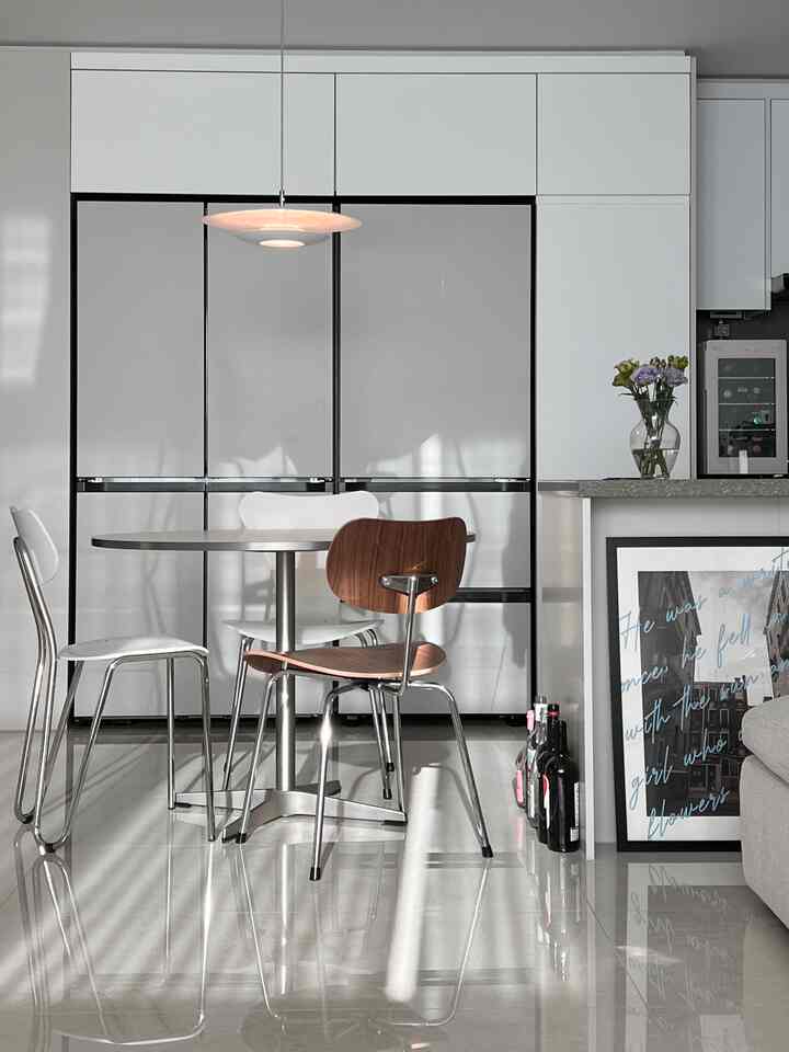 White tone kitchen space featuring steel dining table and chairs with a clean modern atmosphere