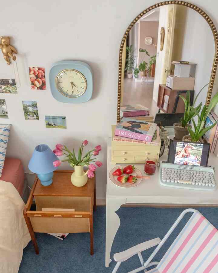 Blue-toned small room featuring vintage furniture, a desk with a vase and table lamp creating a cozy atmosphere