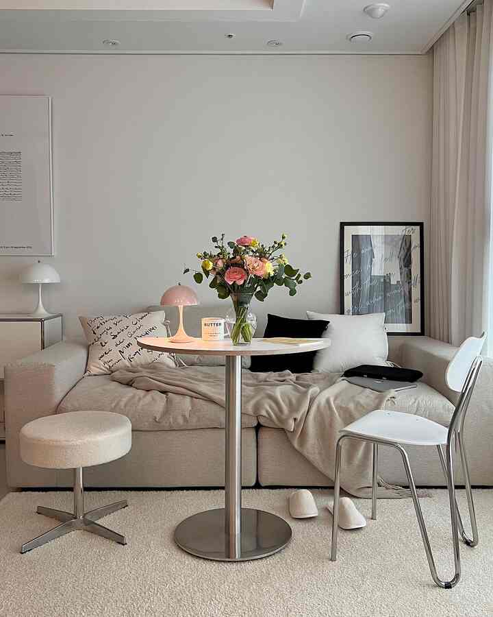Natural-toned living room featuring a beige fabric sofa and round table with a simple, modern atmosphere