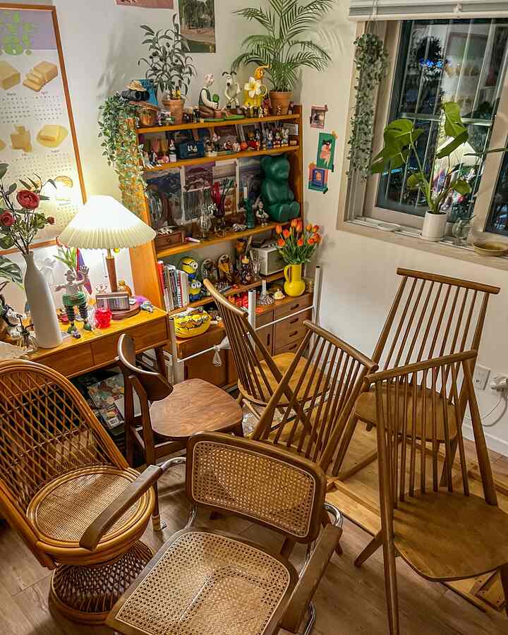 暖かみのあるウッドトーンとラタン素材が映える、小さくて賑やかなダイニングルーム。多様な椅子とヴィンテージ雑貨が魅力的に配置された空間