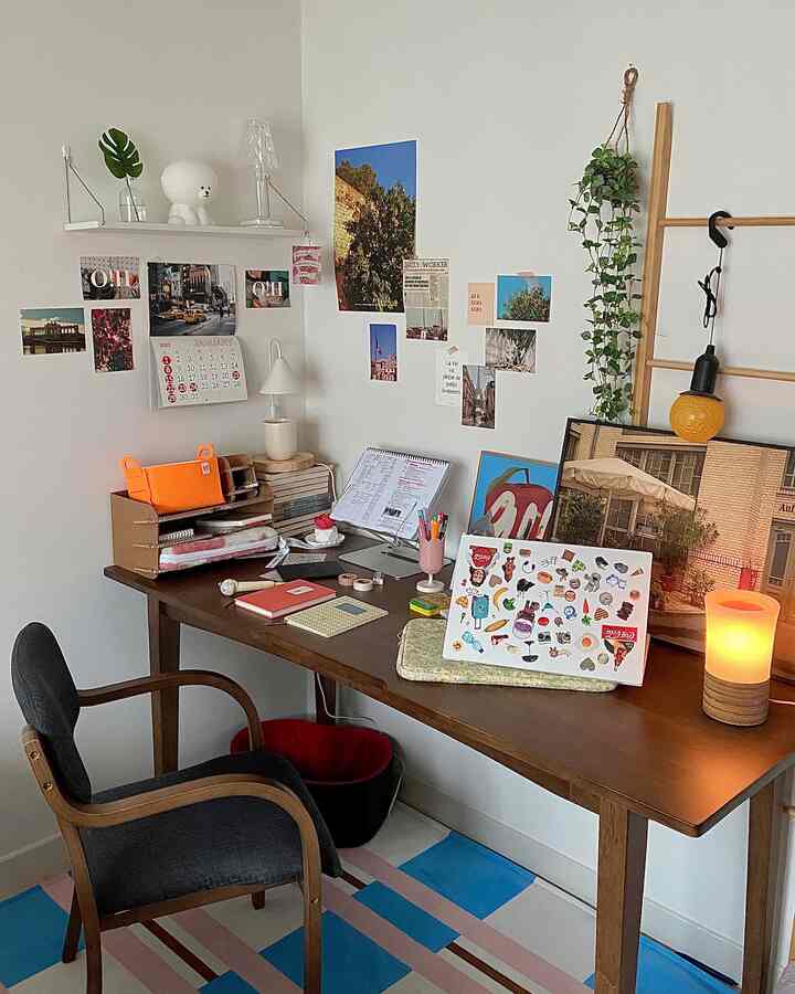 ブラウンの木製デスクとネイビーのクッション付きアームチェアが置かれた落ち着いた書斎のインテリア