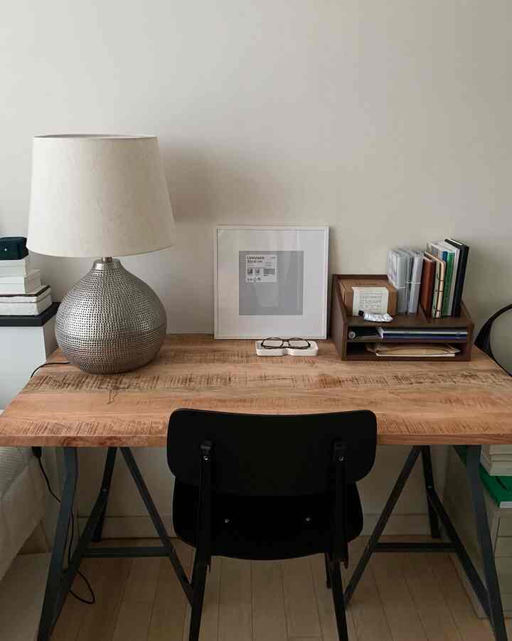 Natural tone wooden desk with black chair in a simple, tidy home office space