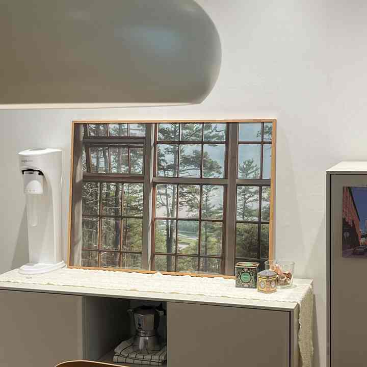 A beige-toned wall and white IKEA storage cabinet with a pendant light arranged in a modern dining room interior