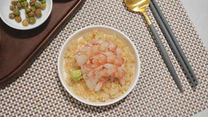 白と茶色のトーンのダイニングテーブルに、エビの刺身とわさびが載った器とカトラリーセットが配置された雰囲気のあるホームカフェ空間