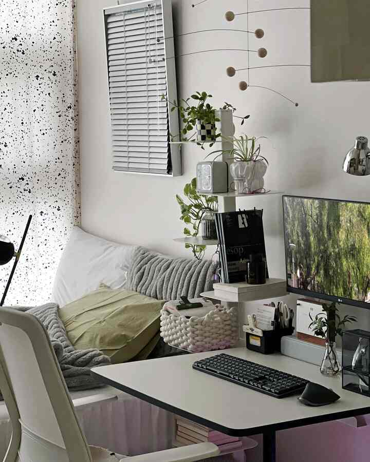 White and beige toned living room and home office featuring clean desk, sofa, and plants in a harmonious setup