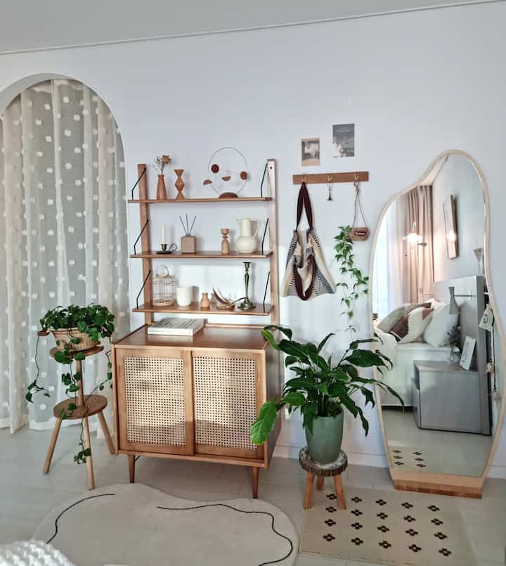 White and wood tone bedroom featuring vintage coat rack and plants with cozy interior design