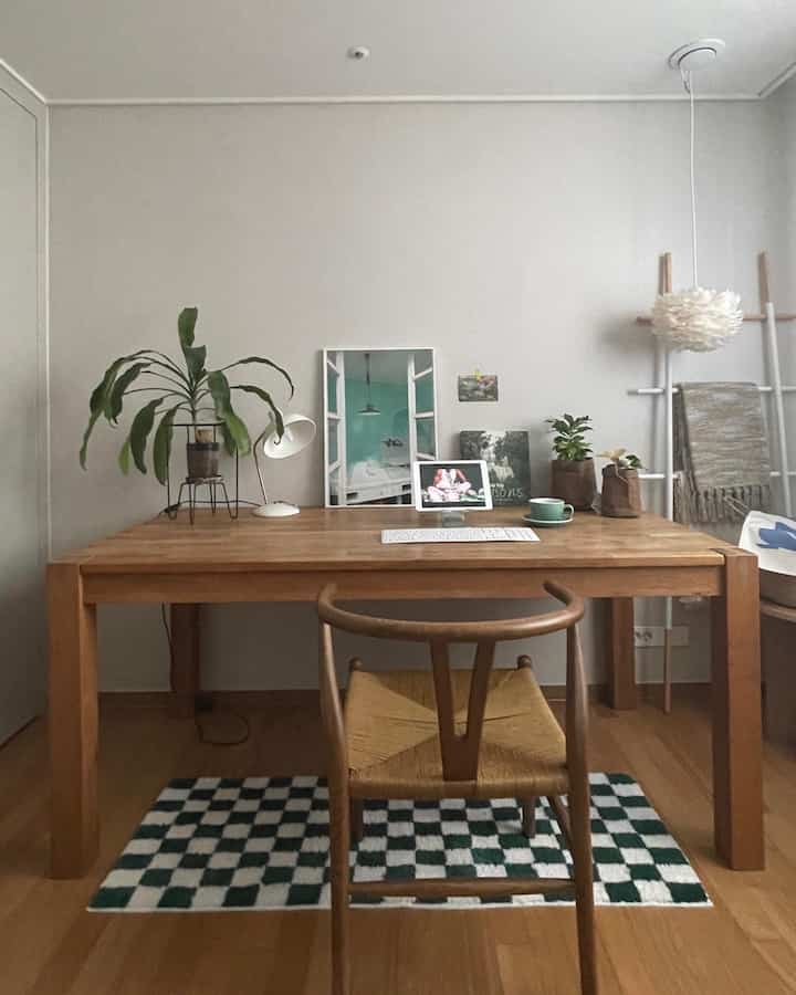 ナチュラルな木目調と緑の植物が配されたミニマルなダイニングの印象的な空間