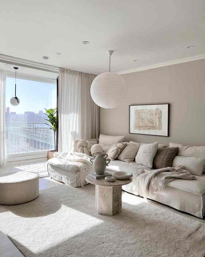 Bright and simple living room with natural toned wall, white sectional sofa, and round coffee table