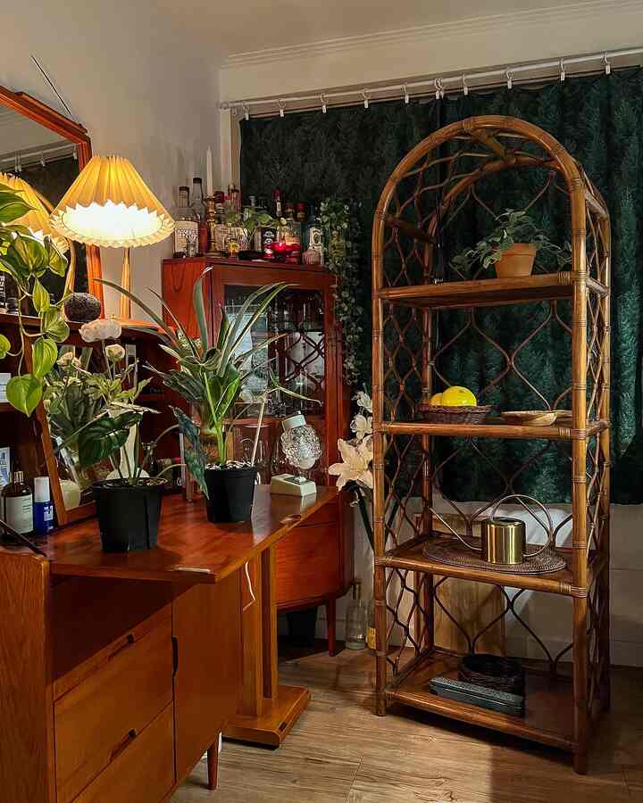 Warm brown wood tones and deep green cafe-style home bar featuring plants and decorative objets creating a cozy atmosphere