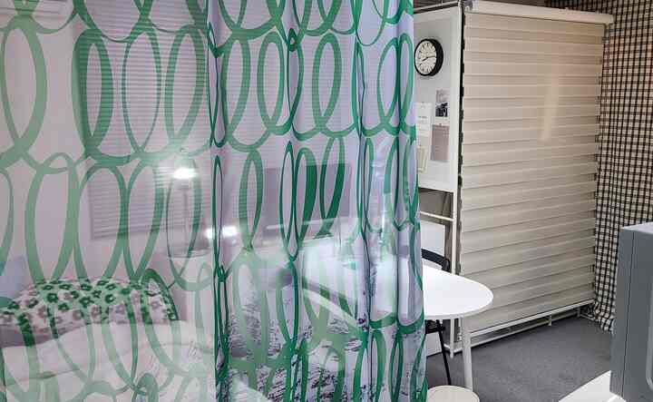 White-toned entrance and kitchen space featuring green chiffon curtains, creating a clean and stylish atmosphere