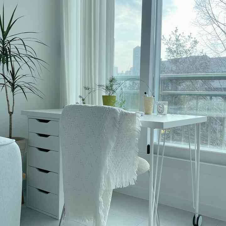 ホワイト調のリビングの一角にあるホームオフィス空間、机と植物が配置された落ち着いた清潔感のあるインテリア