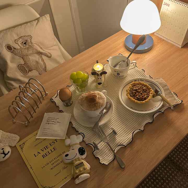 Cozy natural-toned dining table featuring home cafe drinks, dessert, and a table lamp with warm lighting