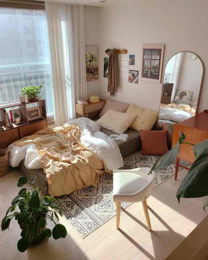 Natural tone small living room featuring a sofa bed and rug with cozy atmosphere