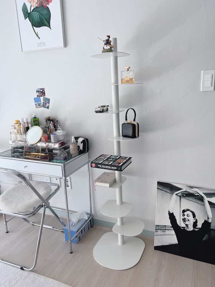 白とウッドトーンが調和した小さな部屋、モダンな化粧台と本棚が配置された印象的な空間