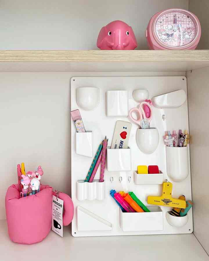 ホワイトとピンクのトーンが特徴的な子供部屋のデスク整理スペース、カラフルな文房具が整頓された雰囲気のあるインテリア