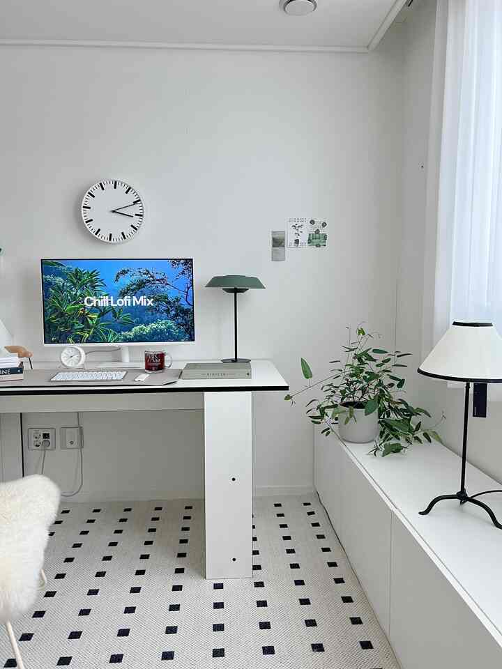白を基調としたコンパクトなホームオフィス、机と時計、植物が配置されたモダンで清潔感のあるインテリア