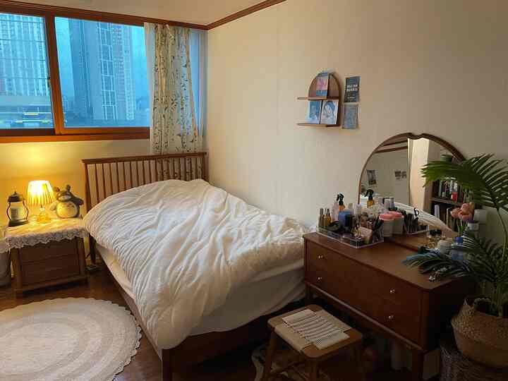 温かみのあるブラウンの木目調が特徴の寝室、木製のベッドと化粧台が配置された自然で落ち着いた空間