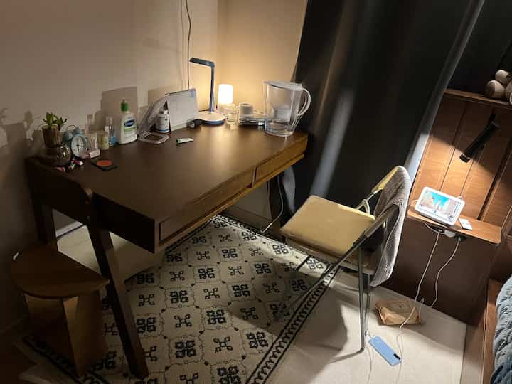 ブラウンとベージュのトーンのワンルーム、木製デスクと椅子が配置された居心地の良いホームオフィスの空間