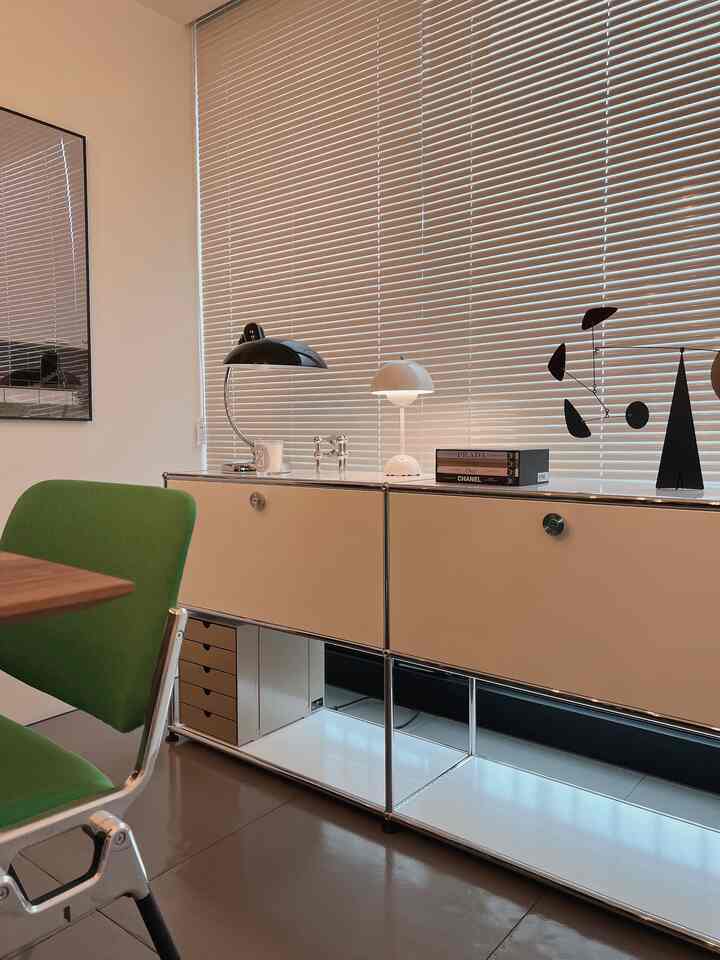 White and green toned dining room featuring a Mid-Century Modern sideboard and dining chairs in a clean space