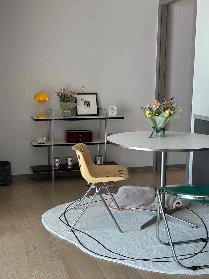 ホワイトと木目調が調和したミッドセンチュリーモダンスタイルのシンプルな円形ダイニングスペース