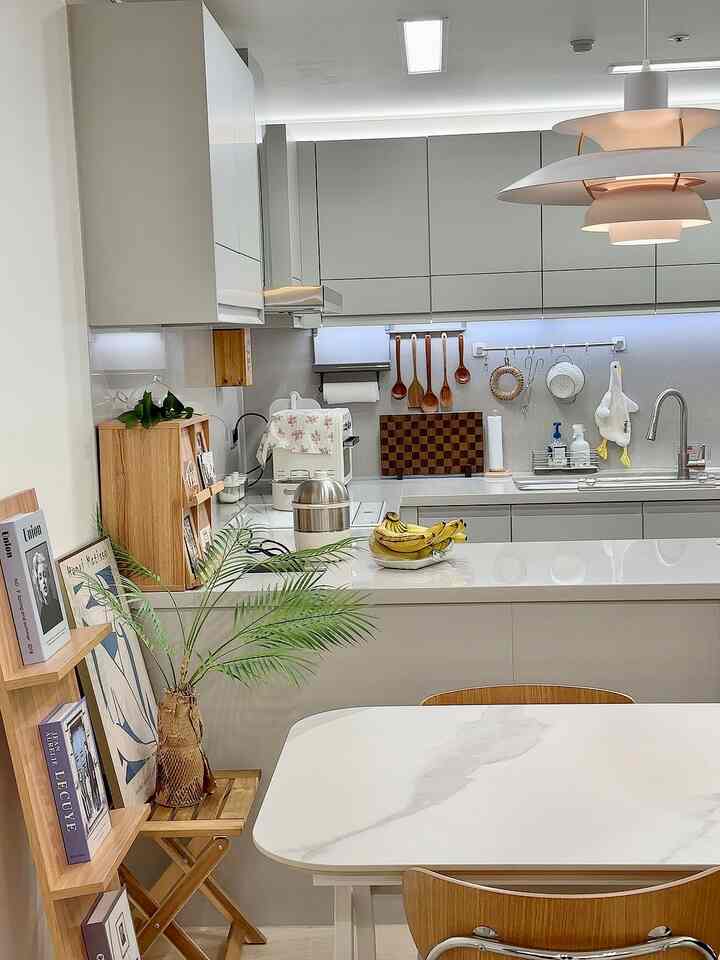 A clean kitchen and dining space blending white, gray, and wood tones with a modern aesthetic