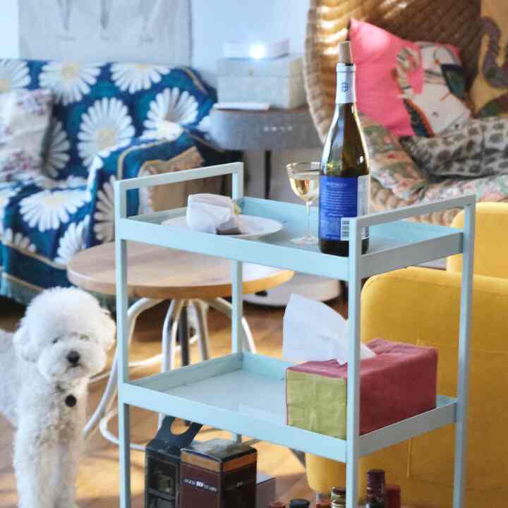 Nordic tone living room featuring a yellow armchair, blue daisy-patterned sofa cover, and a bar cart creating a cozy atmosphere