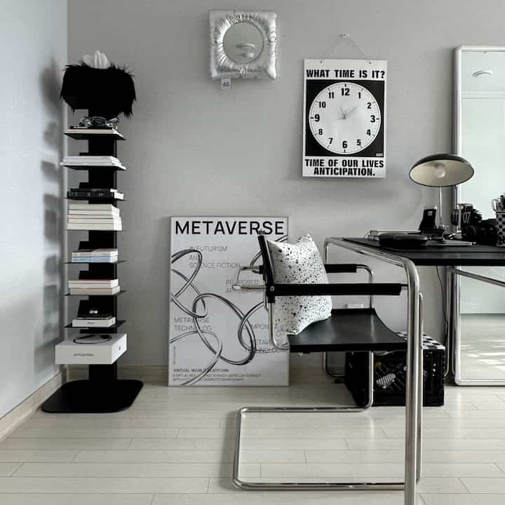 White walls and floors with black furniture and accessories in a Mid-Century Modern style home office space