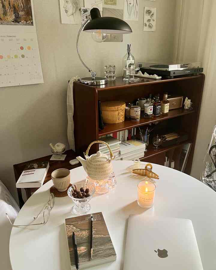 Natural-style living room featuring warm wood furniture and a white table set up as a home cafe