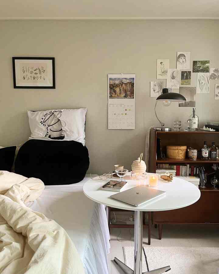 ナチュラルウッドのキャビネットと白いベッドがあるミニマルで整った一人暮らしの寝室