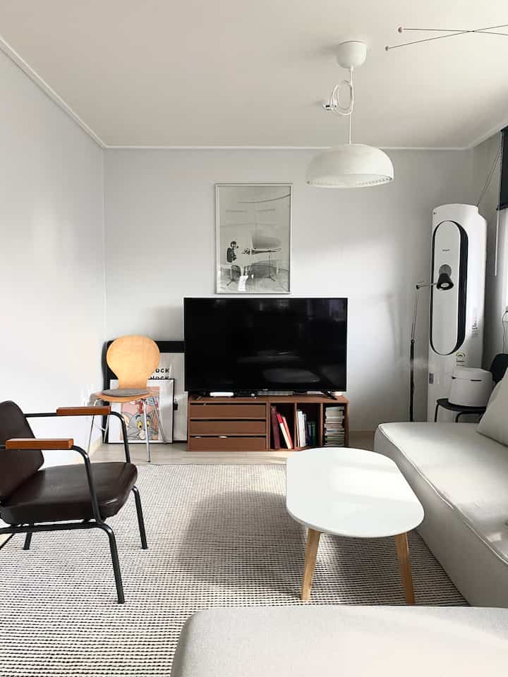 Nordic-style living room with white walls and wood furniture, beige sofa and rug creating a cozy atmosphere