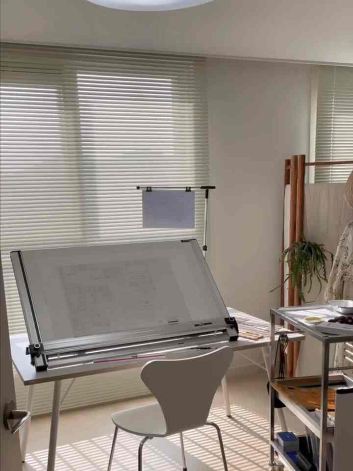 White-toned study space featuring a Desker drafting table and chair centrally arranged, creating a clean workspace