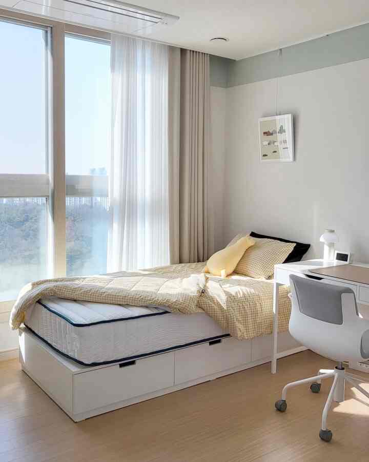 Natural beige and white toned bedroom featuring a storage bed and desk, creating a cozy and clean space