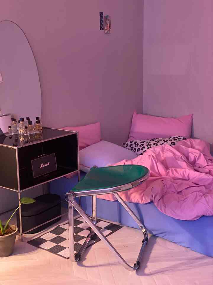 ピンクと青の色調が印象的な居心地の良い寝室、モダンな家具と観葉植物が配置された雰囲気のあるインテリア