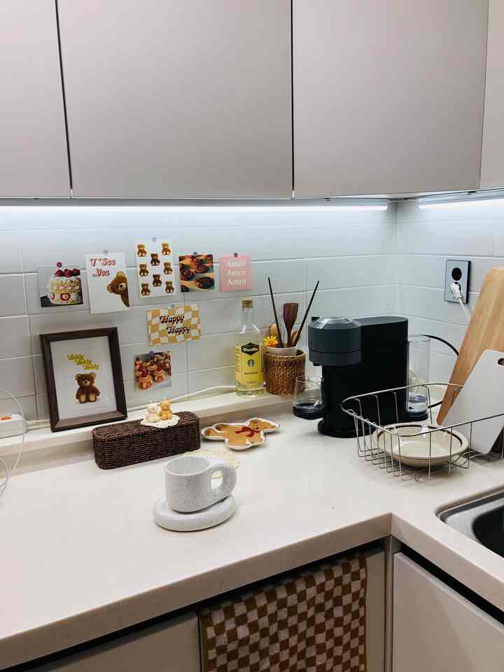 A white and beige tone kitchen home cafe space featuring teddy bear objets and rattan storage creating a cozy atmosphere