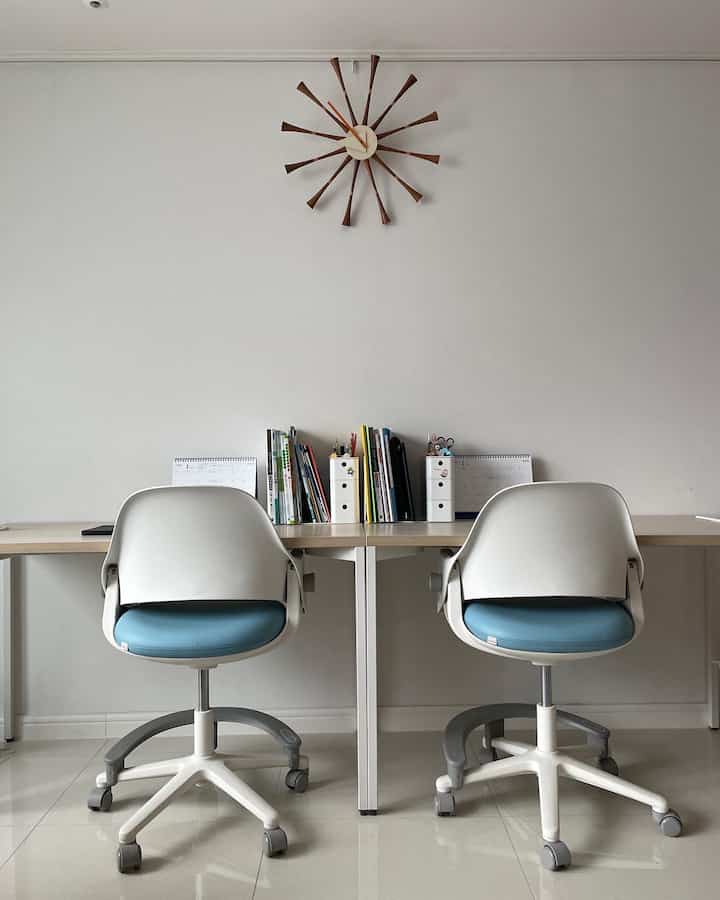 白と青のトーンのリビング、デスカーのデスクとチェアが配置されたシンプルで整った学習スペース