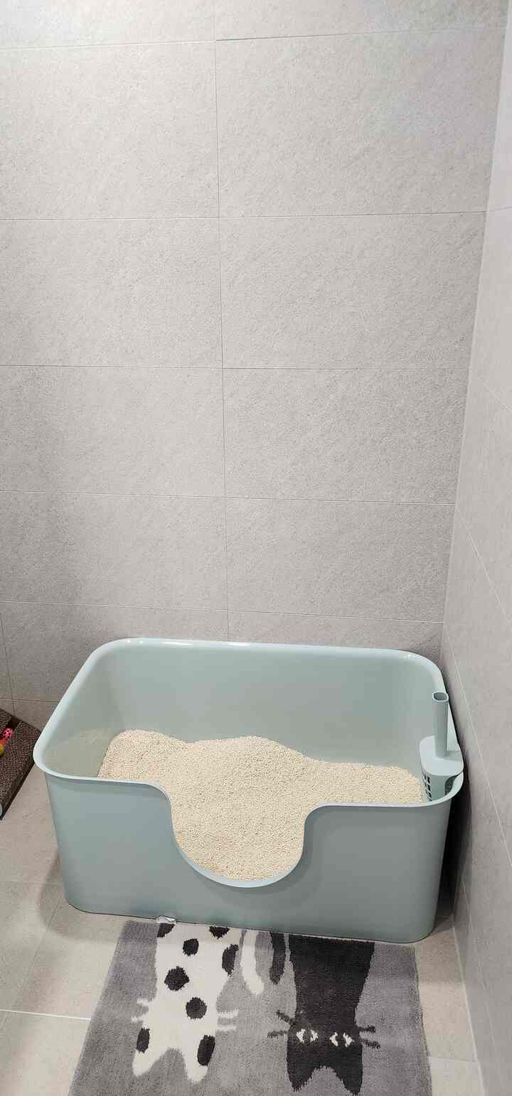 Natural color and beige toned restroom featuring a large cat litter box with a clean and comfortable atmosphere