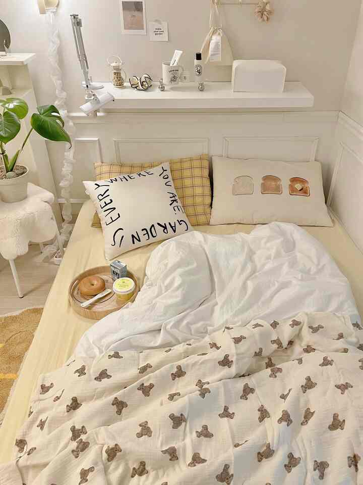 白とナチュラルカラーのワンルーム寝室、枕とマットレスが配置された雰囲気のある空間